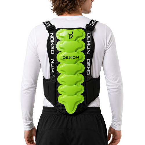 Person wearing a black and green back protector with 'Demon' branding on a white background