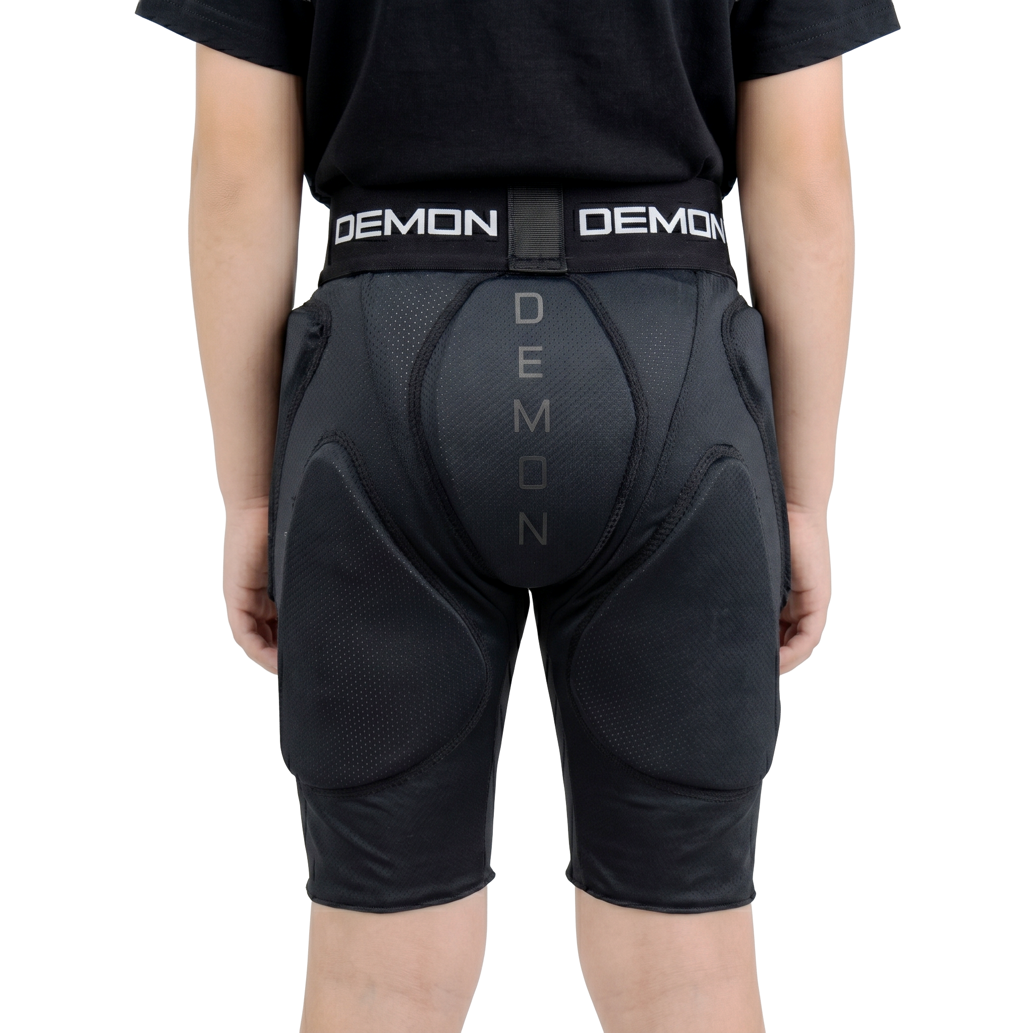 Person wearing black protective shorts with 'Demon' branding on a white background