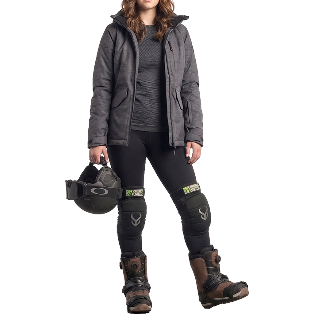 Person wearing a gray jacket, black pants with knee pads, and brown boots holding a helmet on a white background