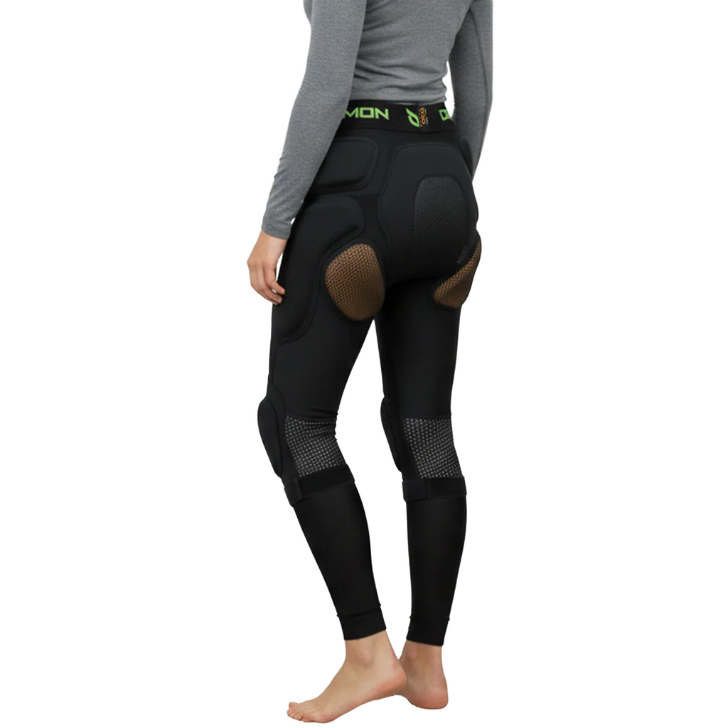 Person wearing black protective riding pants with a white background