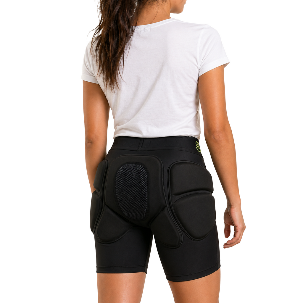 Person wearing black protective shorts with padding on a white background