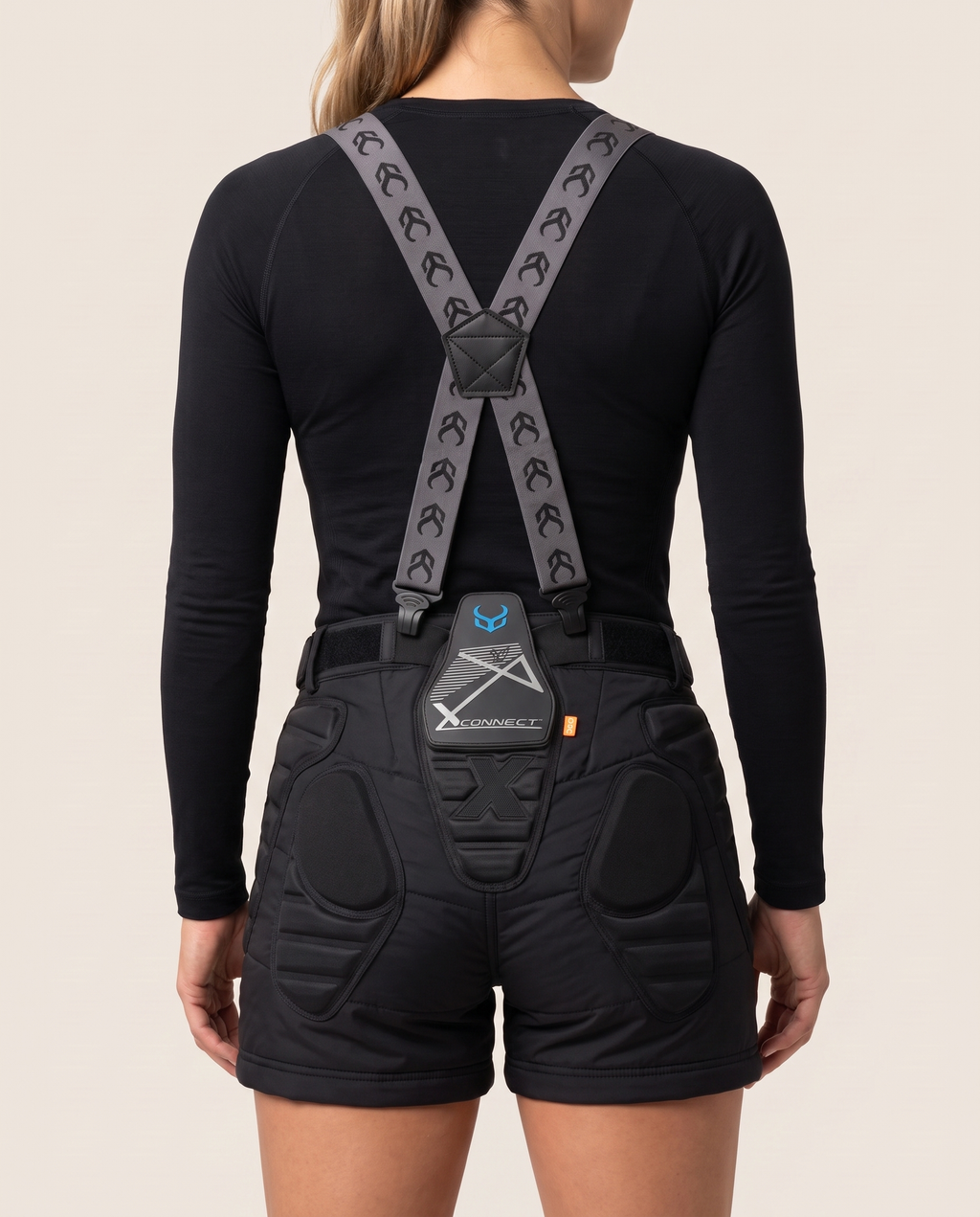 Female model, back view, wearing Demon Snow Suspenders over V7 women's padded shorts